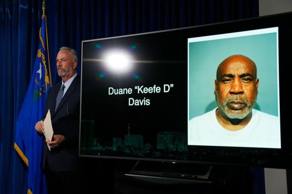 Clark County District Attorney Steve Wolfson stands beside a photo of Duane 