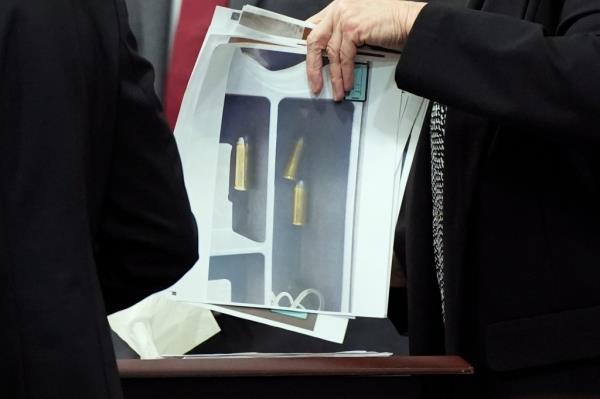 Pictures of ammunition evidence being held. 