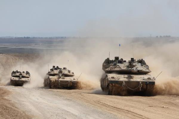A co<em></em>nvoy of Israeli armoured vehicles makes its way to the northern Gaza Strip, as seen from the border with Gaza in southern Israel.