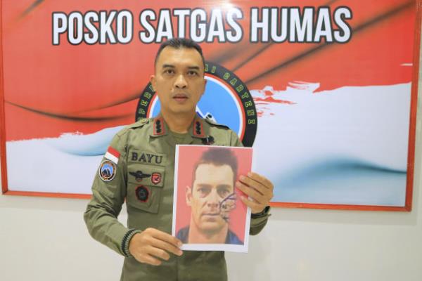 Bayu Suseno, a spokesperson for the Cartenz 2024 Peace Task Force, holds a portrait of Glen Malcolm Conning, a pilot for Indo<em></em>nesian aviation company PT Intan Angkasa Air Service.