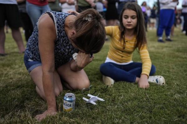 Brandy Rickaba and her daughter Emilie pray during a candlelight vigil for the slain students and teachers at Apalachee High School in Winder, Georgia.