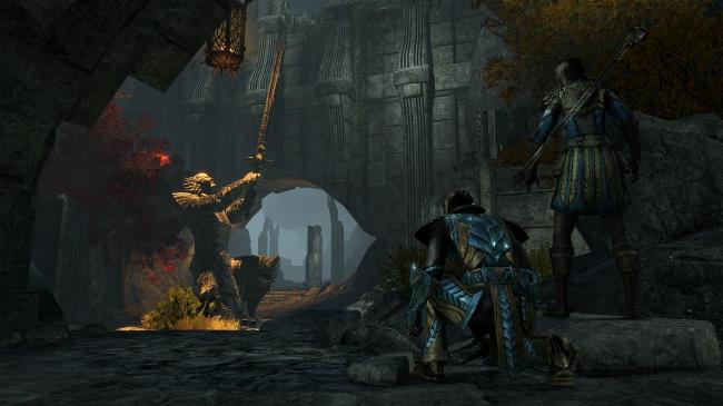 ESO Gold Road screenshot of two adventurers hiding in an ayleid ruin, looking at a statue pointing a sword into the sky, illuminated by a beam of sunlight